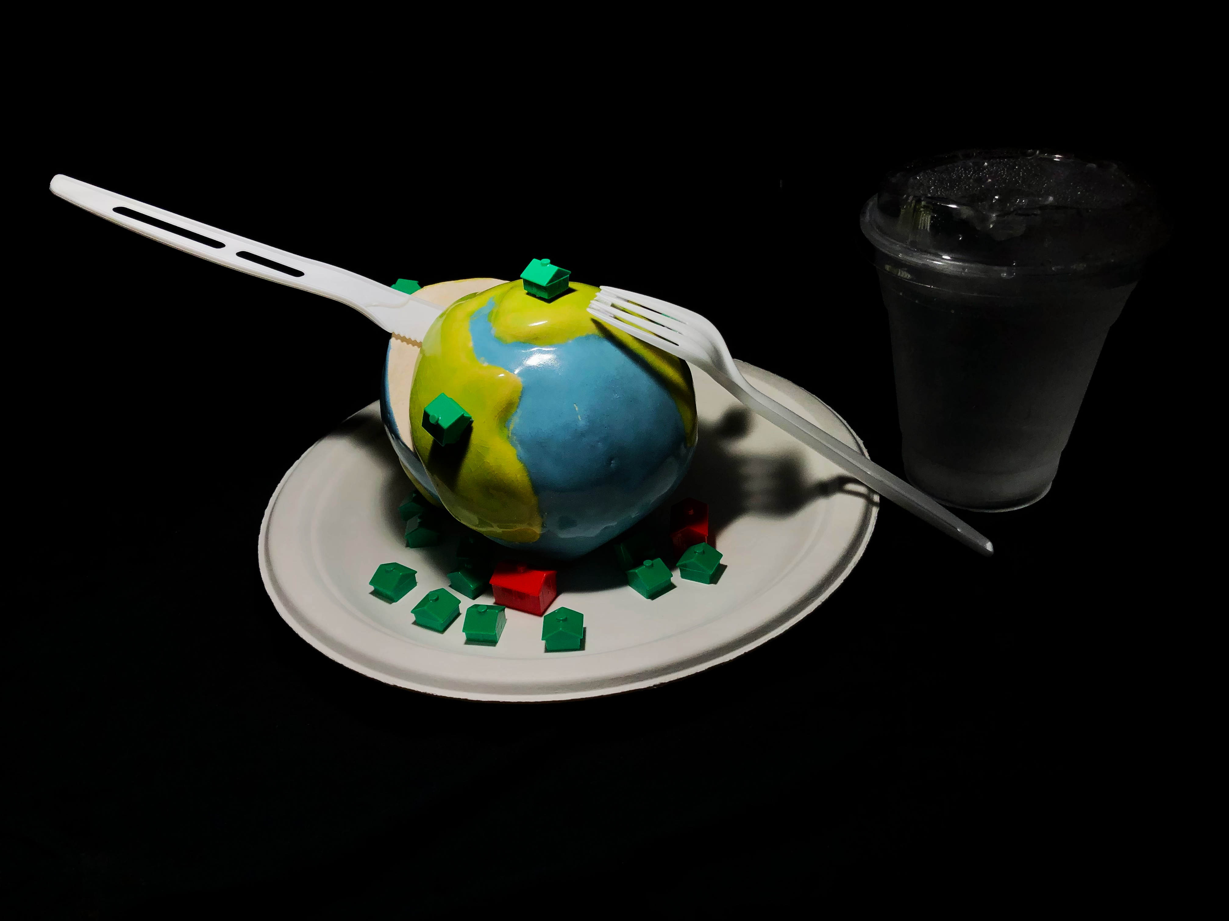 Surreal sculpture of Earth and Monopoly pieces